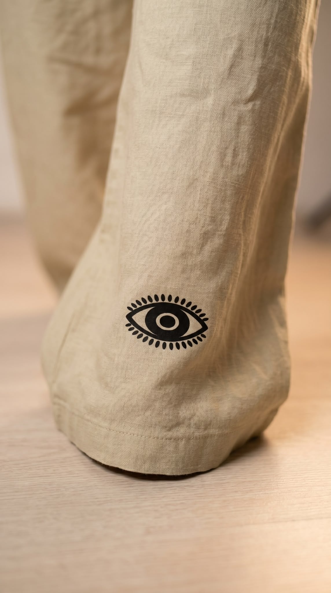 Détail de l'œil noir floqué sur l'ourlet du pantalon Luna